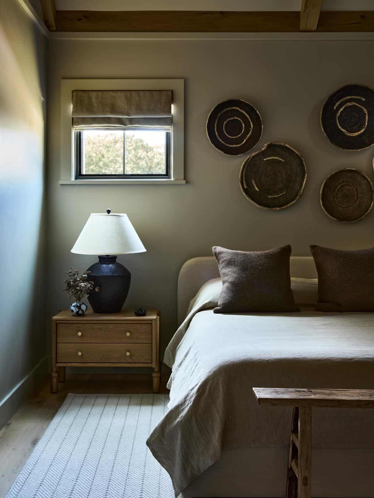 Bedroom with woven wall plates and a dark ceramic table lamp