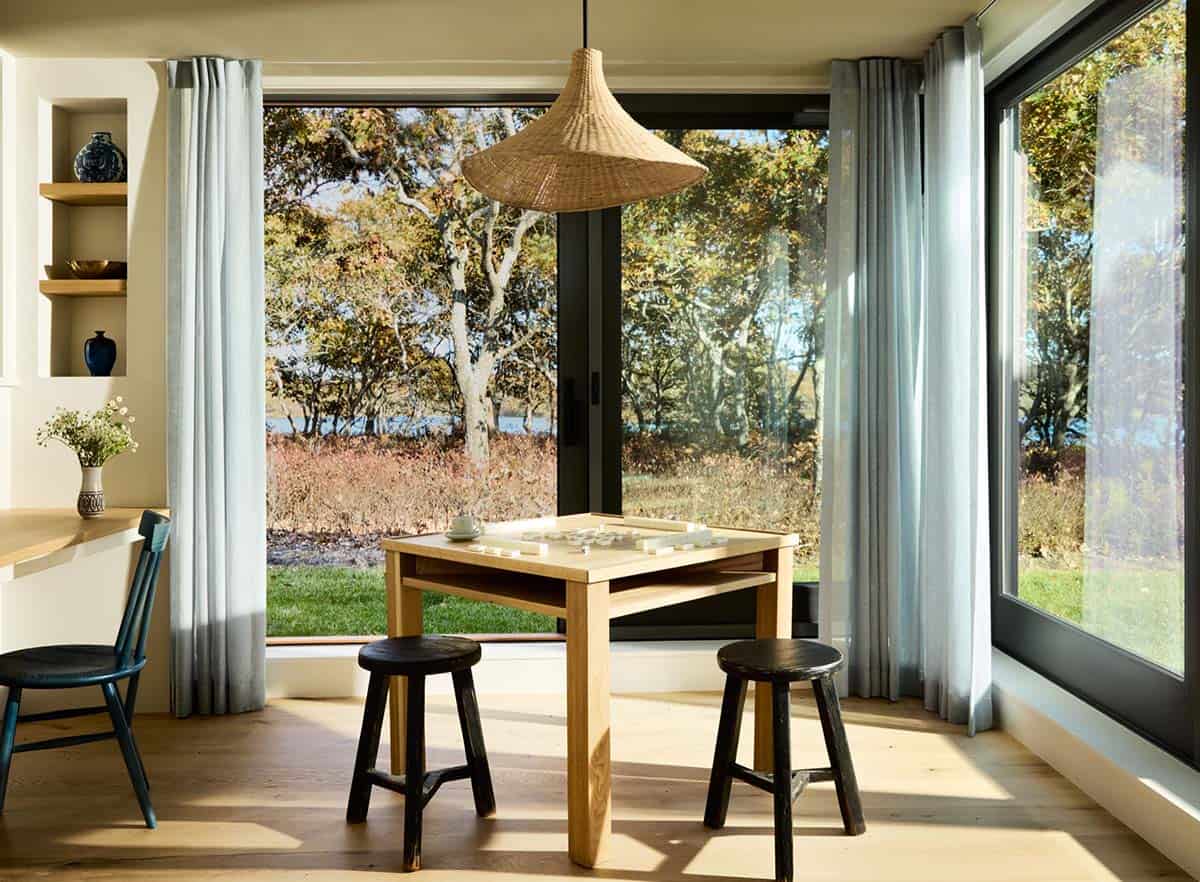 Breakfast nook with game table and woven pendant overlooking the yard