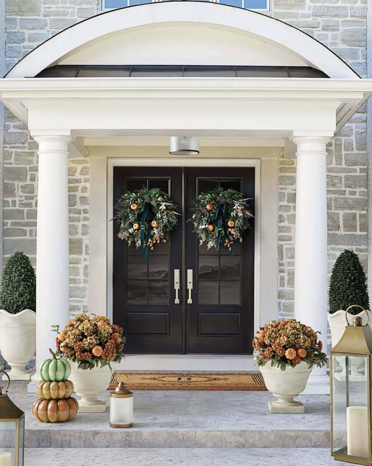 Elegant columned entry with fall hydrangea urns and citrus wreaths