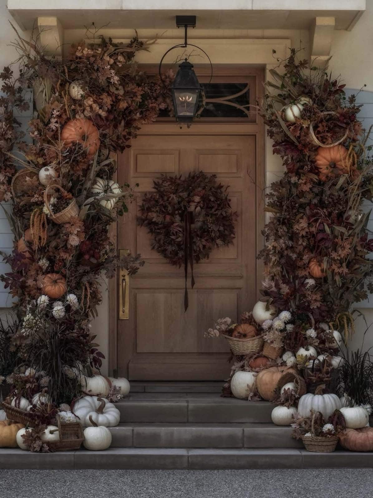 Moody fall doorway framed with dried foliage and pumpkin baskets