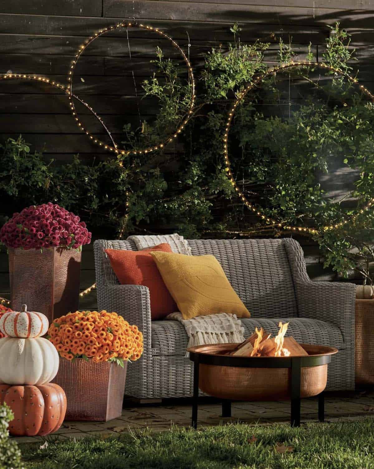 Outdoor patio seating with a copper fire pit and fall string lights