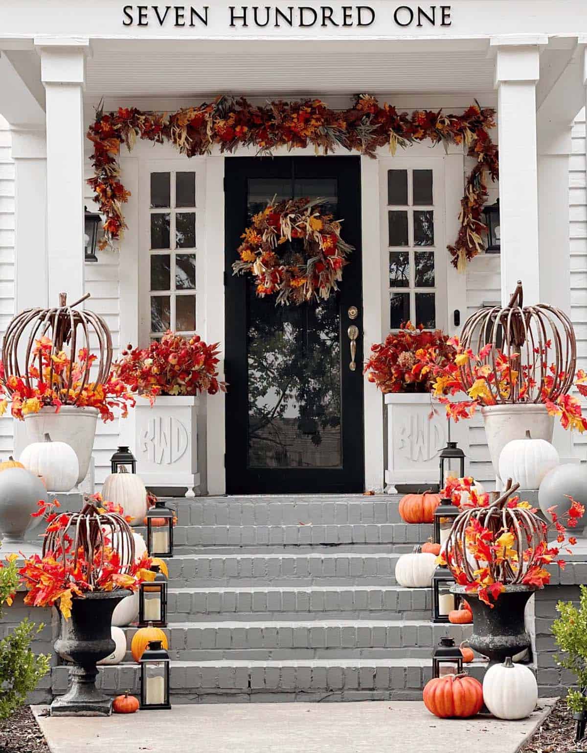 Grey porch steps decorated with grapevine pumpkin topiaries and white pumpkins
