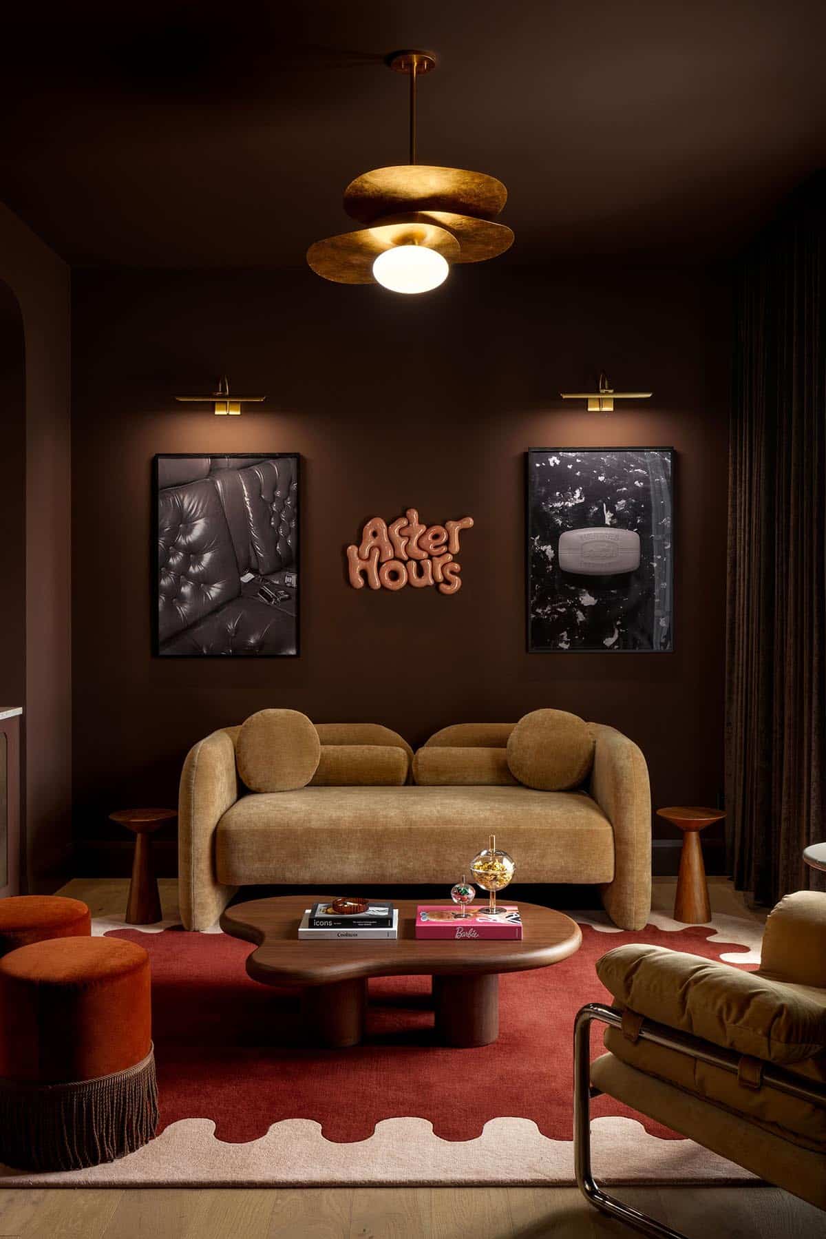 Dark brown lounge with mustard velvet sofa, brass sconces, and "After Hours" sign