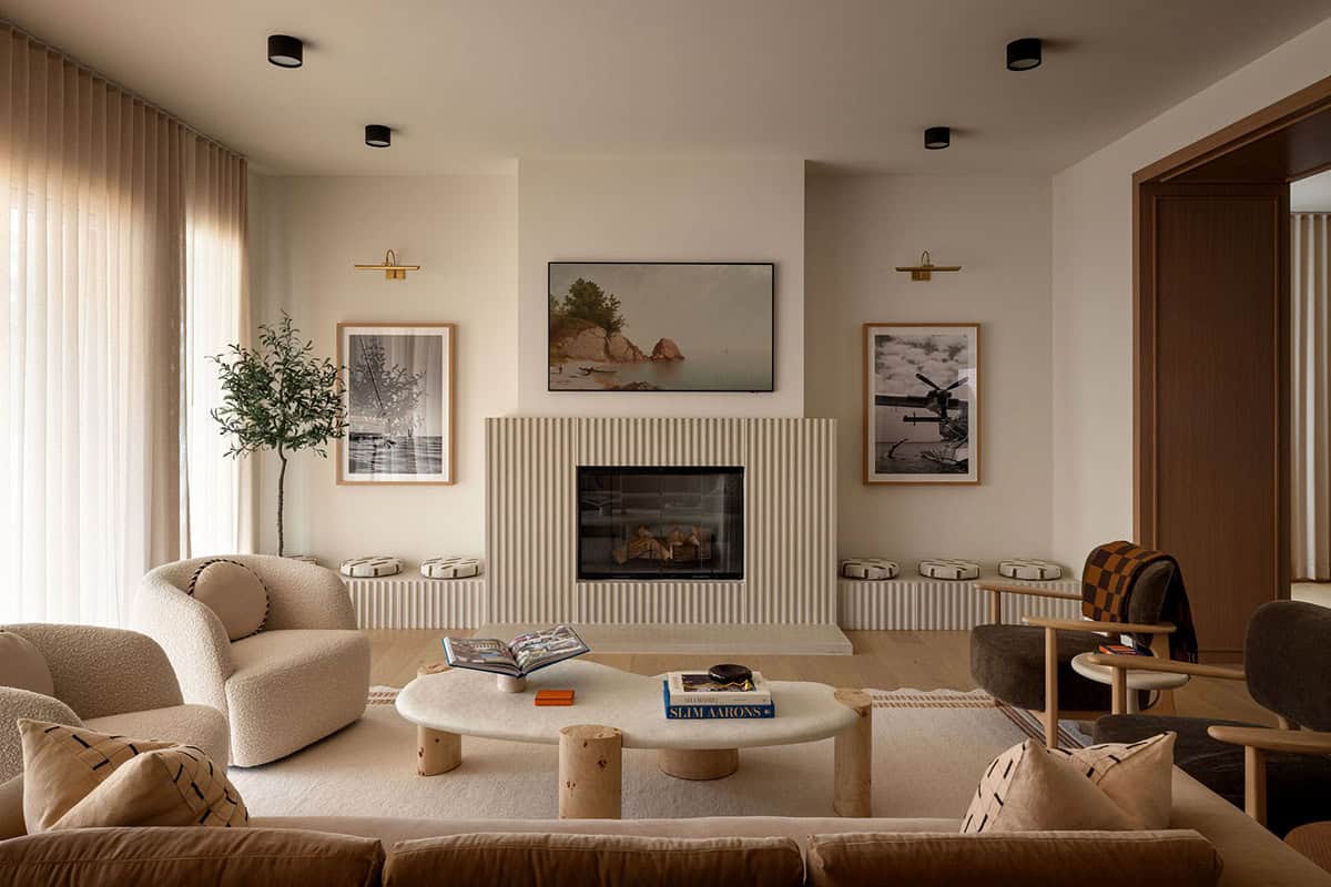 Living room with striped fireplace surround, boucle armchair, and gallery wall