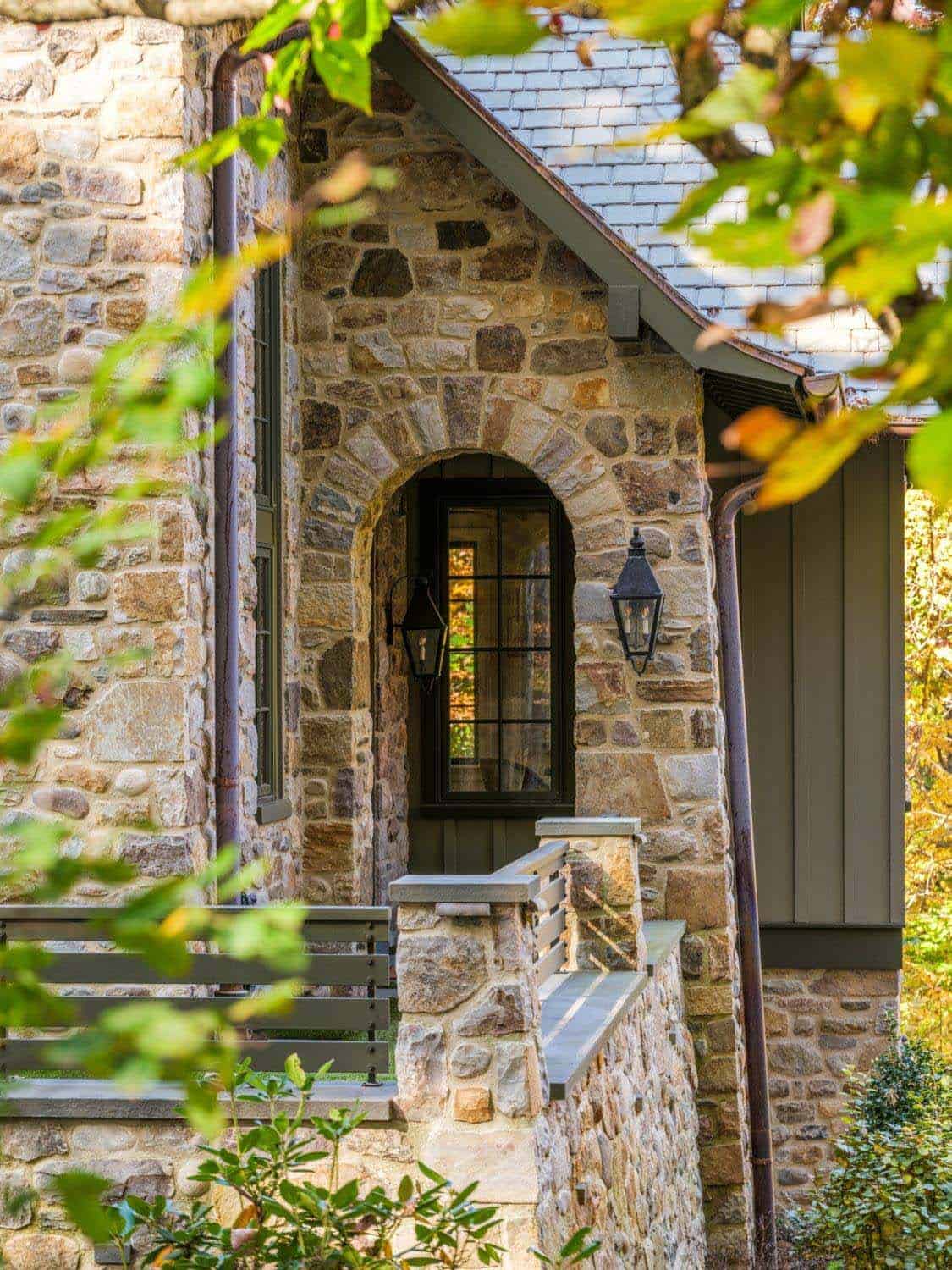 Arched stone entry with iron lantern and curved railing