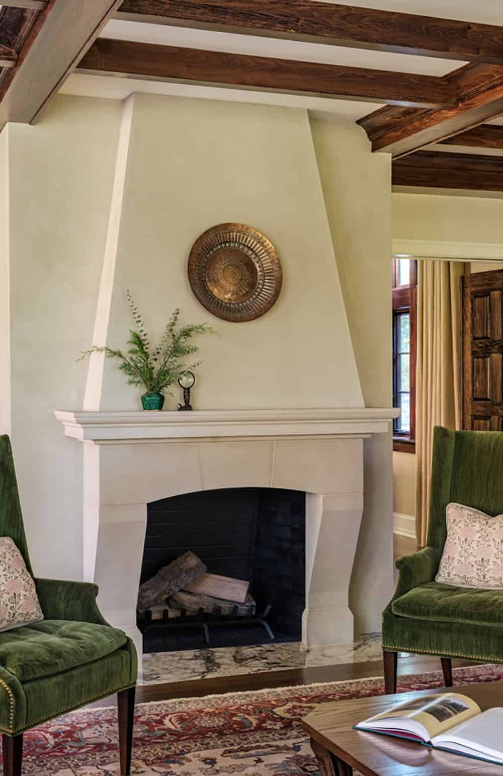 Plaster fireplace surround with round brass medallion above mantel