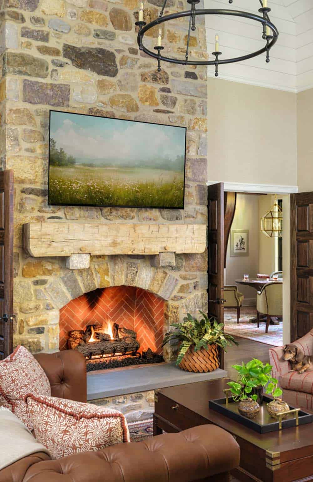 Stone fireplace with rustic mantel beam and herringbone brick surround