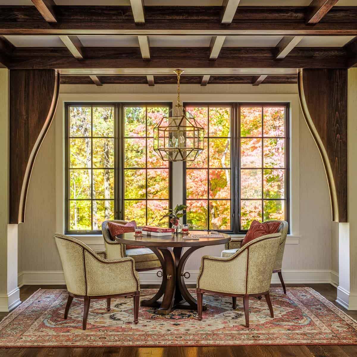 Round game table nestled in window alcove with autumn view