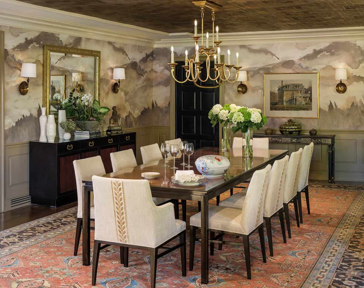 Long dining table set beneath brass candle-style chandelier