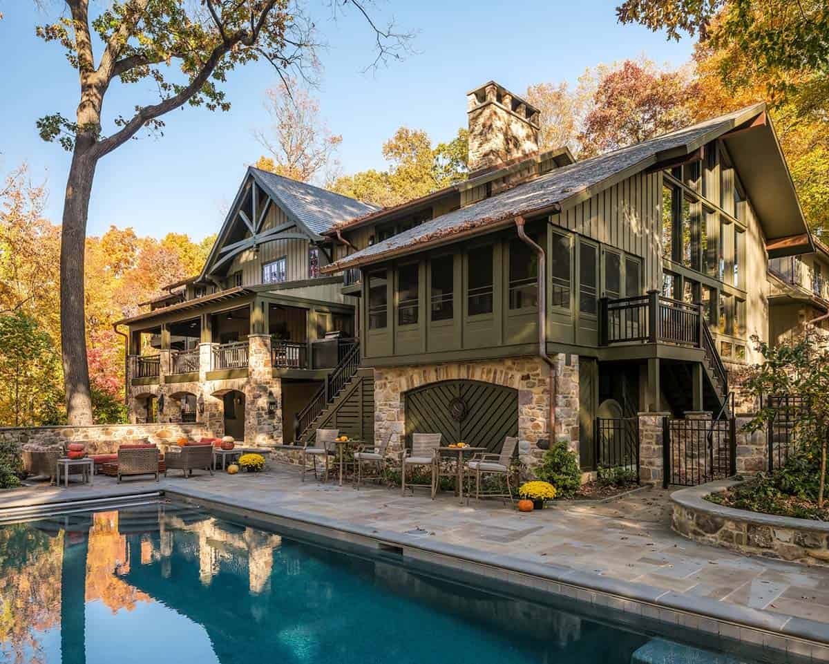 Stone and timber home exterior with pool reflecting fall foliage