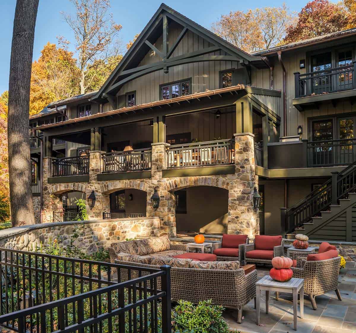 Multi-level stone patio with wicker seating and pumpkin accents