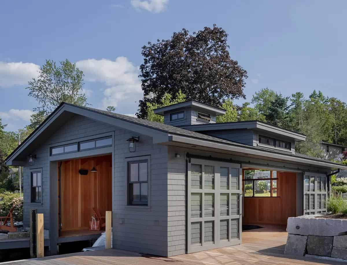 Gray boathouse with open bay doors and cedar wood interior