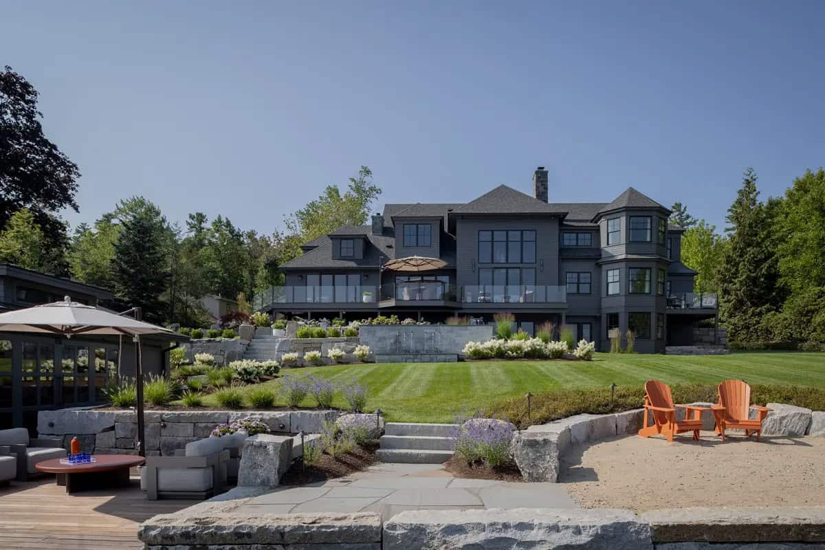 Lake house exterior with green lawn and stone retaining walls