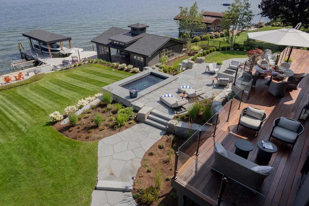 Aerial view of patio, hot tub, and boathouse along the shoreline