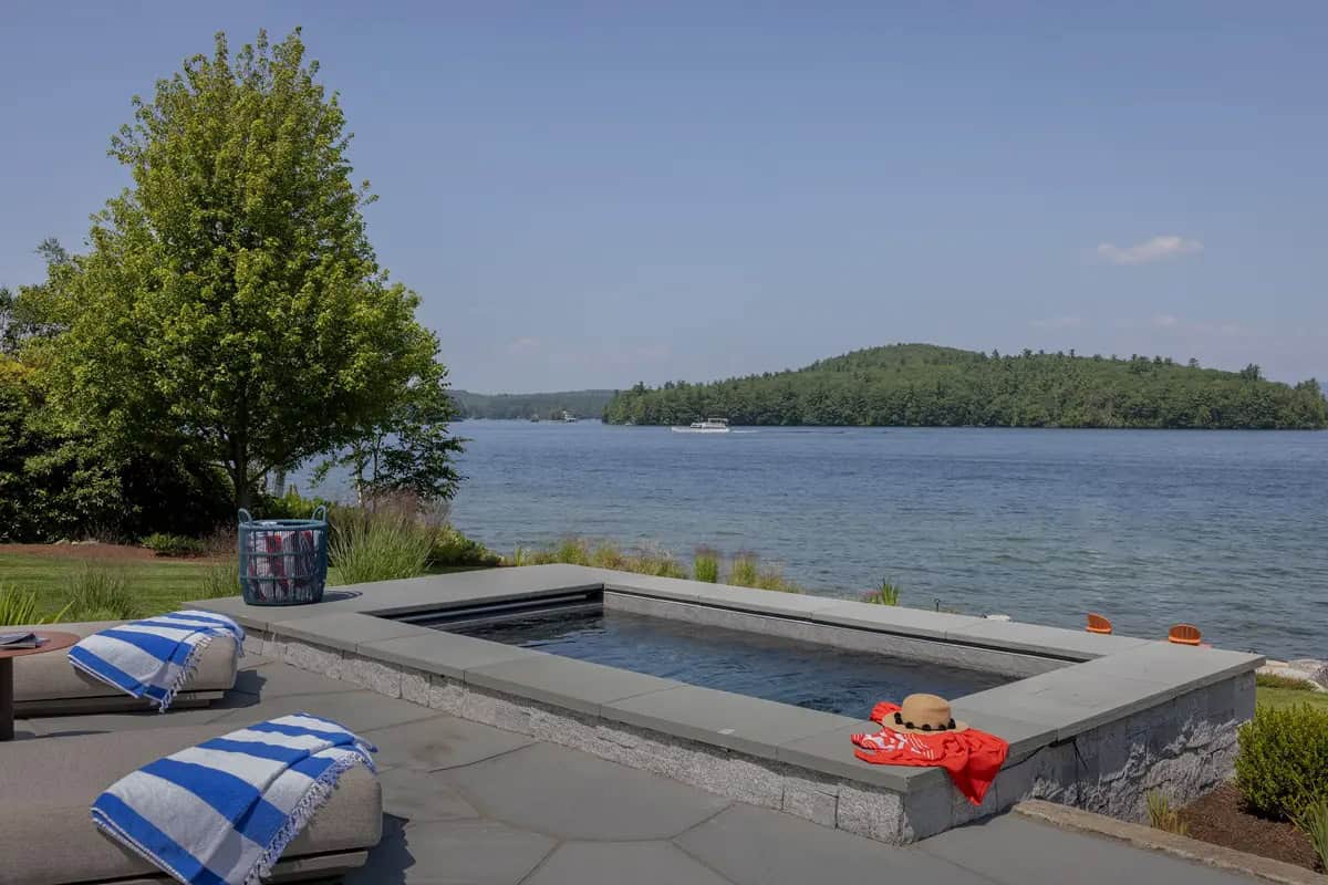 Rectangular hot tub on a stone patio overlooking the lake
