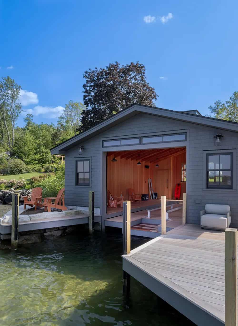 Boathouse with open bay revealing cedar interior and dock chairs