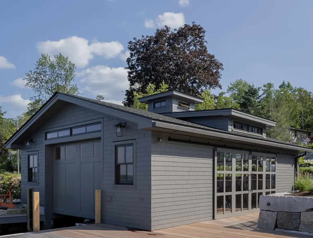 Gray shake-sided boathouse with sliding glass doors and dock