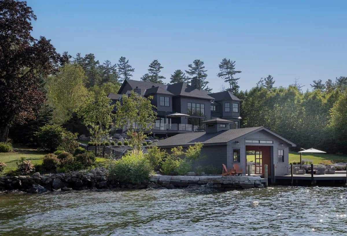 Lake view of the home and red-doored boathouse at dusk