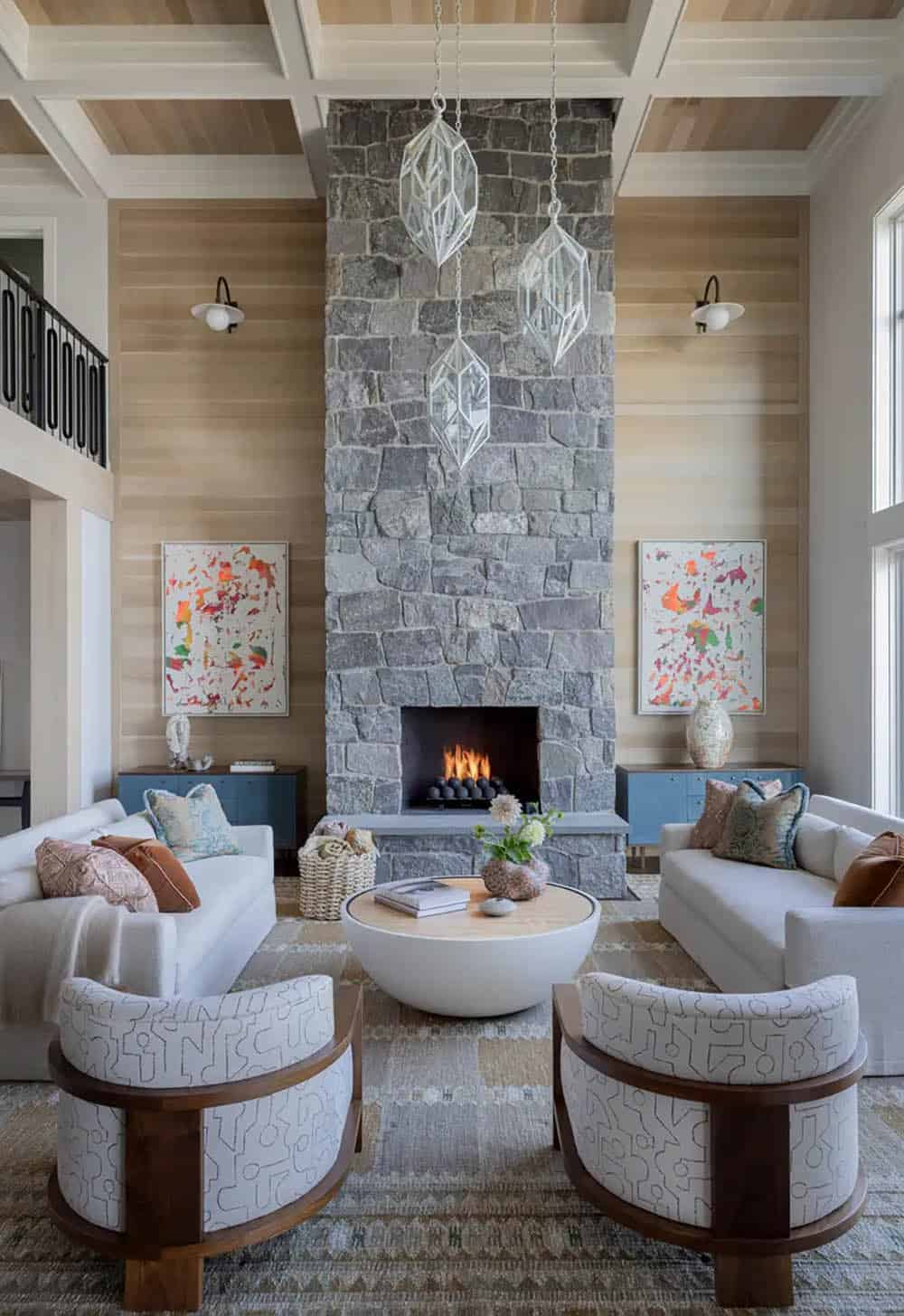 Living room with soaring stone fireplace and geometric pendant lights