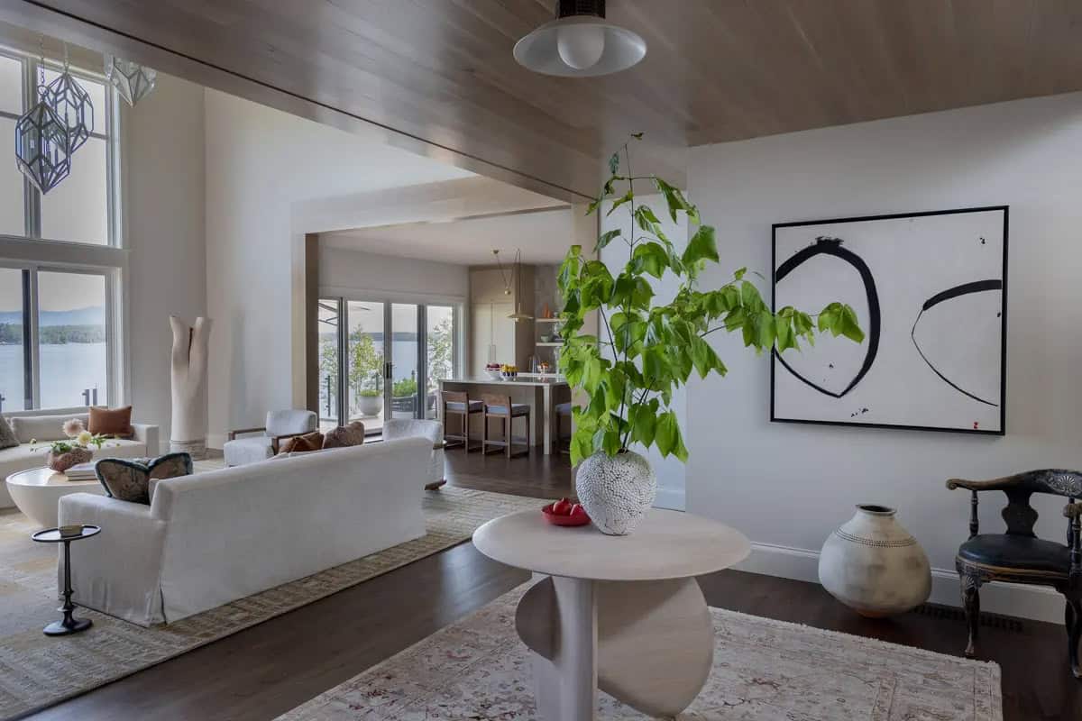 Open-concept living room leading to kitchen with lake views beyond