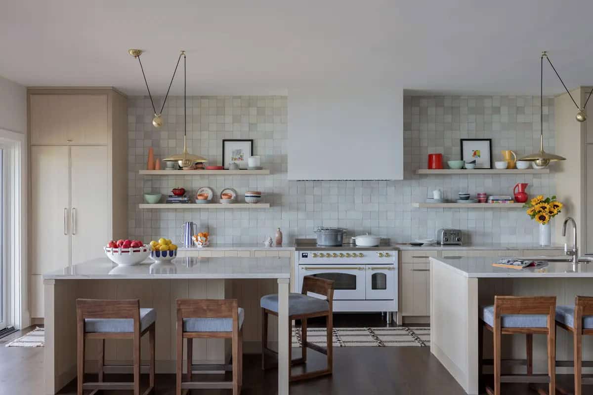 Kitchen with two islands, zellige tile backsplash, and brass pendants