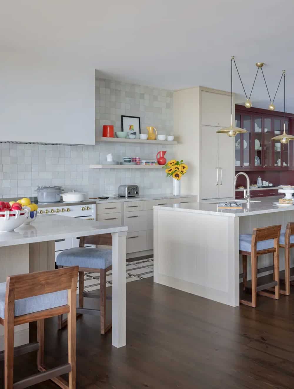Kitchen with white cabinetry, marble counters, and burgundy china cabinet