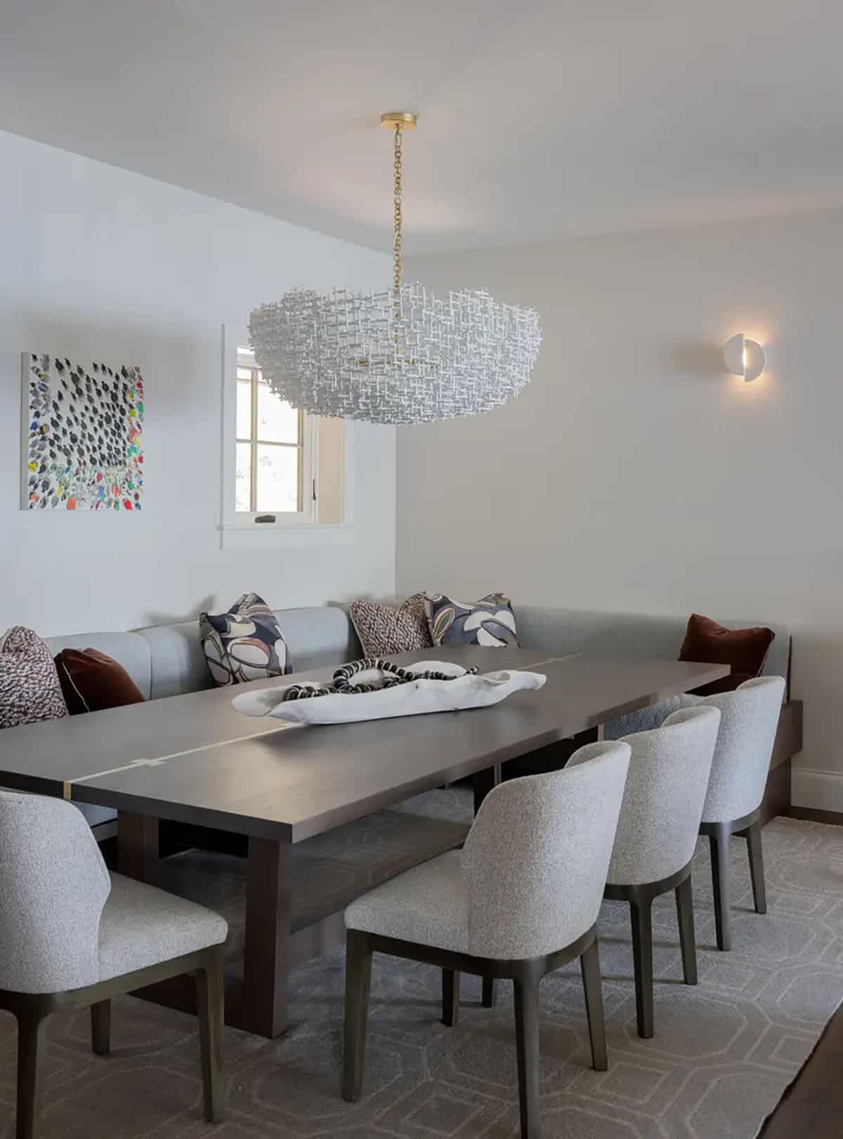 Banquette dining nook with woven chandelier and patterned throw pillows