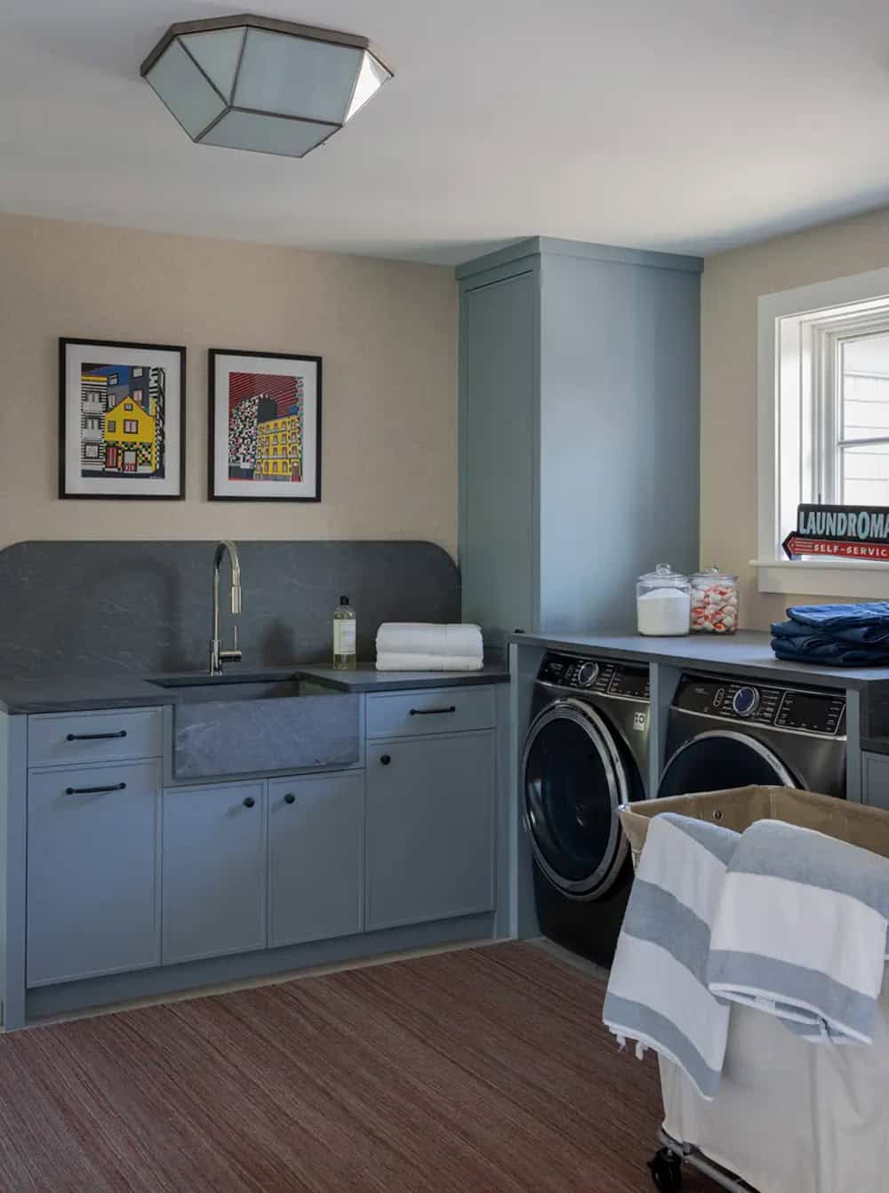 Laundry room with blue cabinetry and marble countertop backsplash