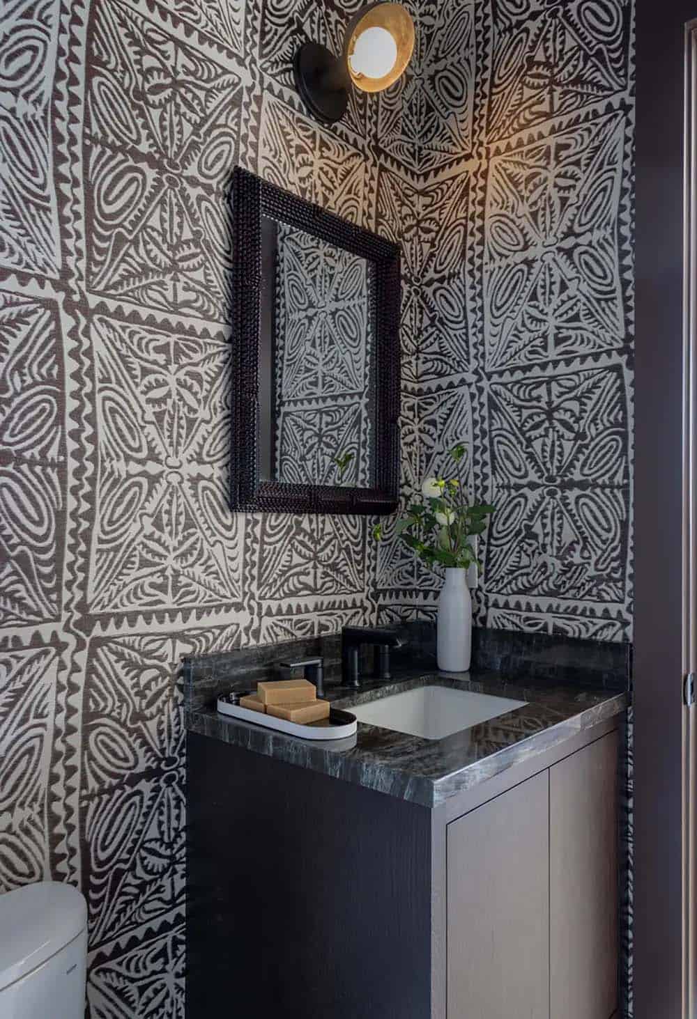 Powder room with graphic wallpaper and dark marble vanity 