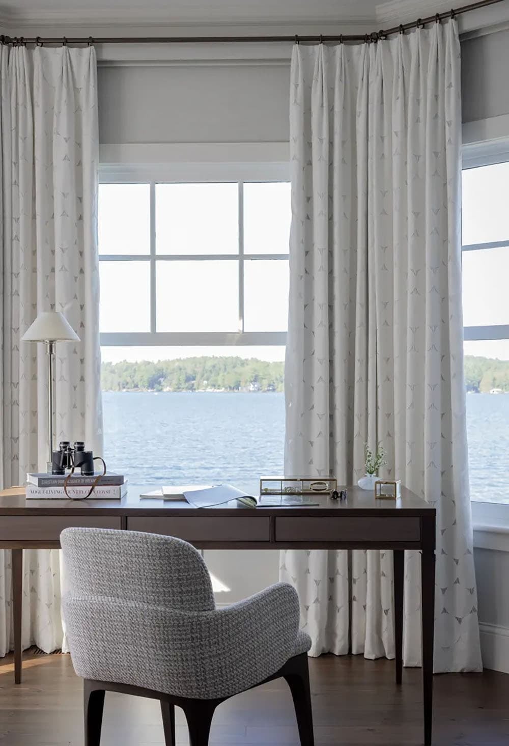 Writing desk in the bedroom with binoculars and floor-to-ceiling lake views