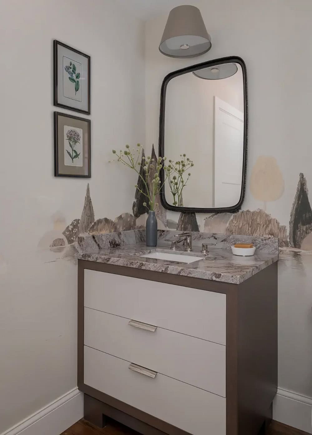 Powder room vanity with mural wallpaper and round black mirror
