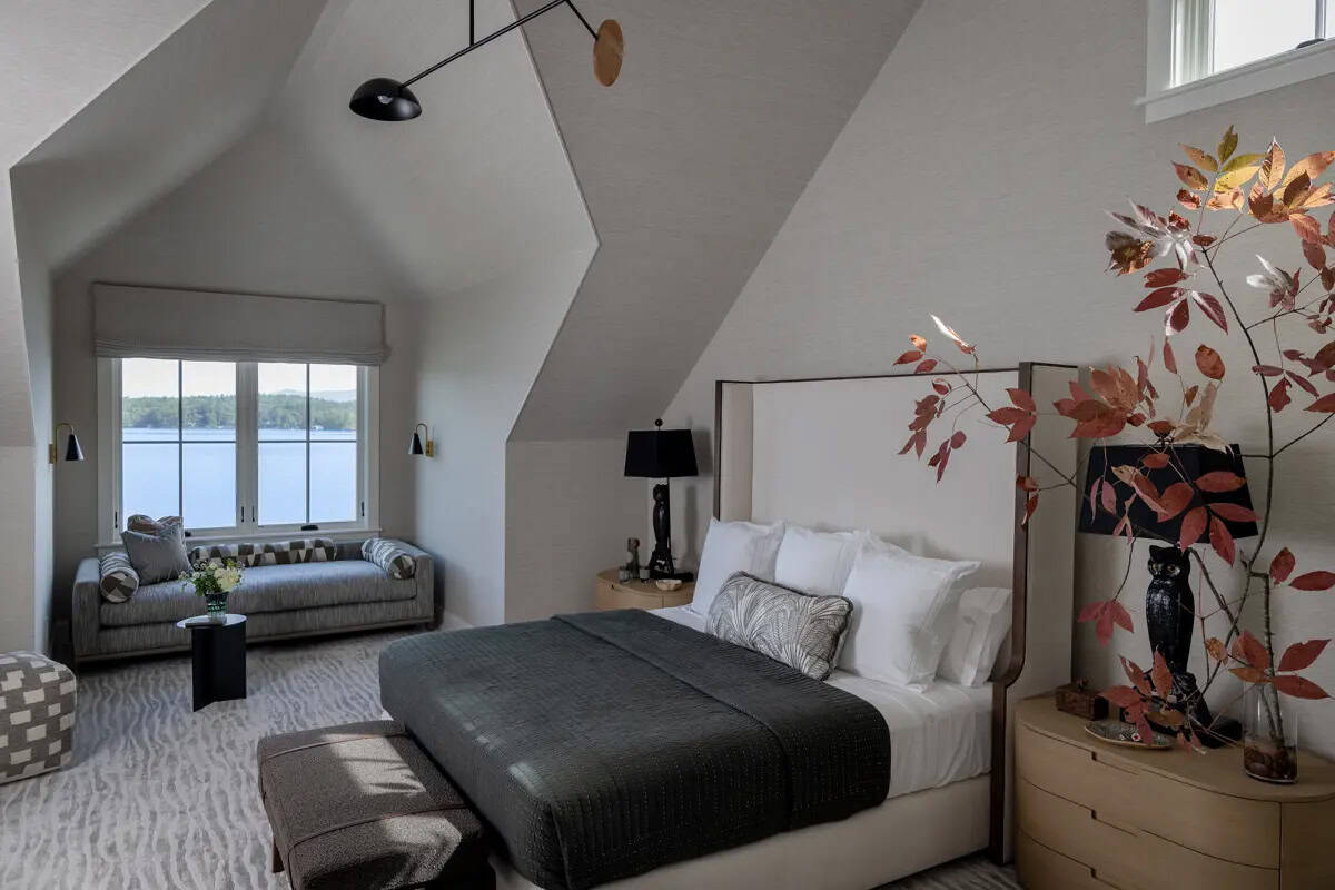 Primary bedroom under sloped ceiling with black leaves branch accent