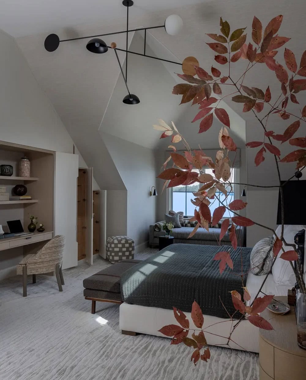 Bedroom sitting area with sculptural black mobile-style light fixture
