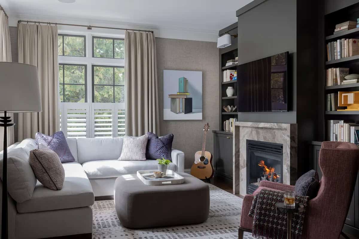 Den with dark built-in shelving and a marble fireplace surround