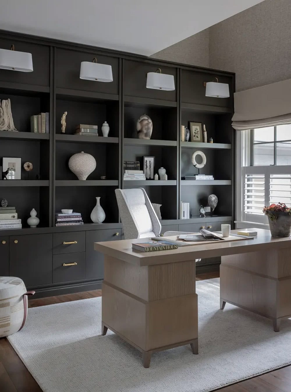 Home office with dark built-in shelving and a wood desk