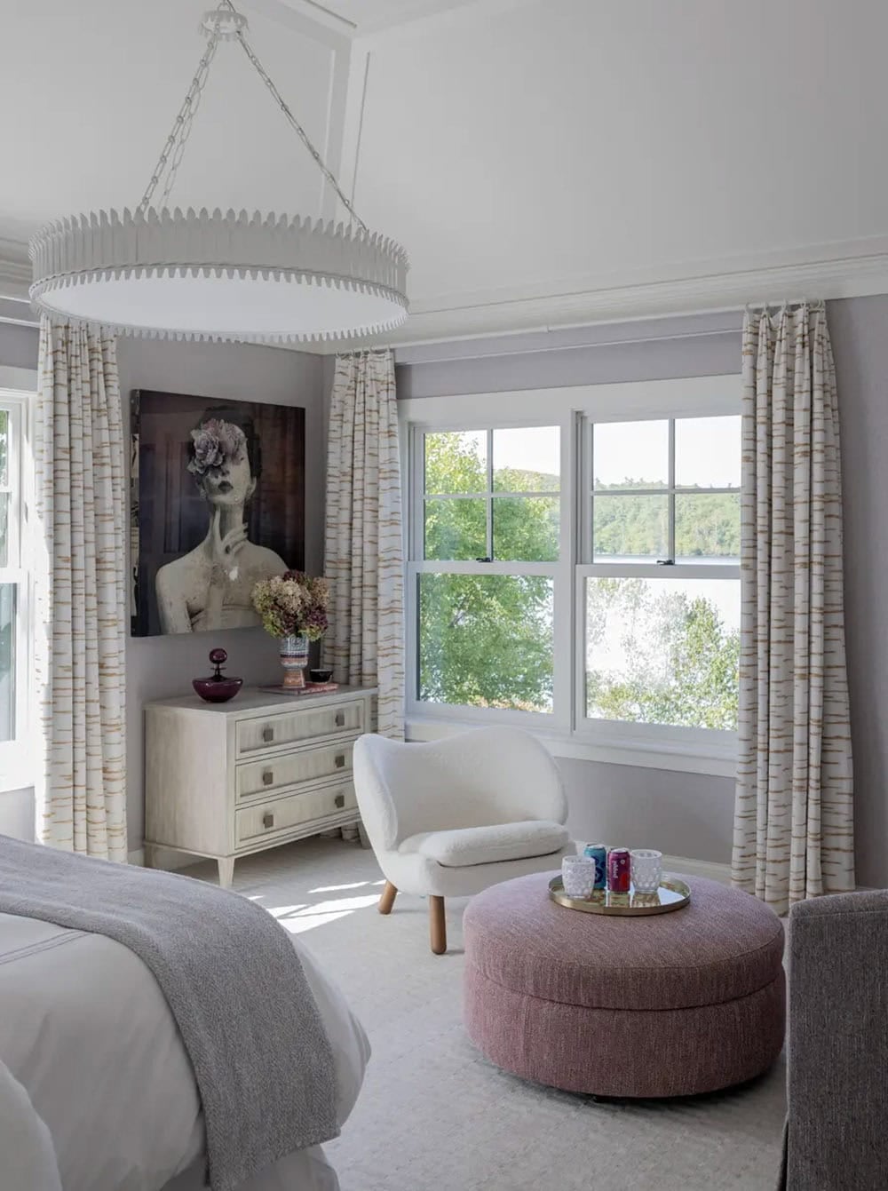 Bedroom sitting nook with scalloped chandelier and pink round ottoman