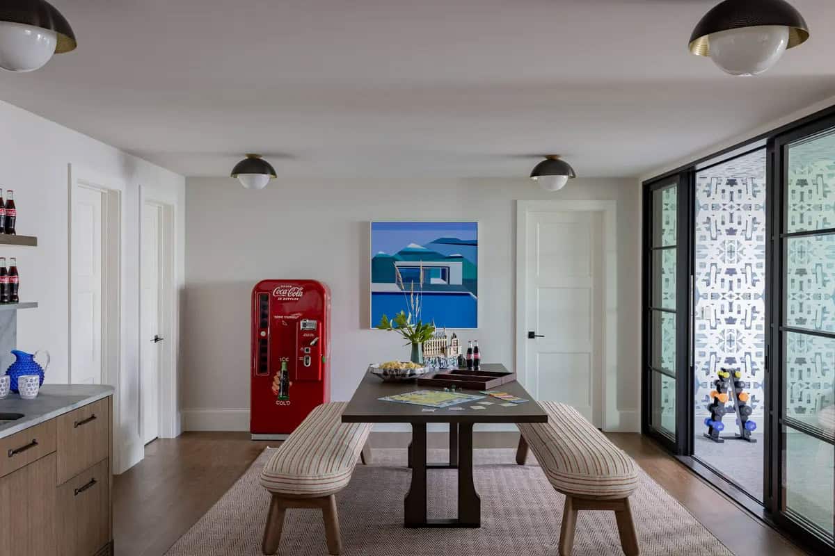 Game room with vintage Coca-Cola machine and striped bench seating