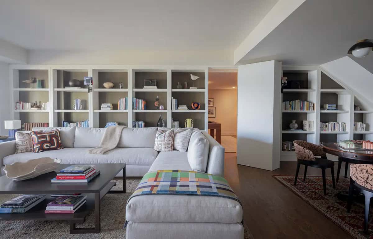 Family room sectional sofa facing built-in shelves beside a pocket door