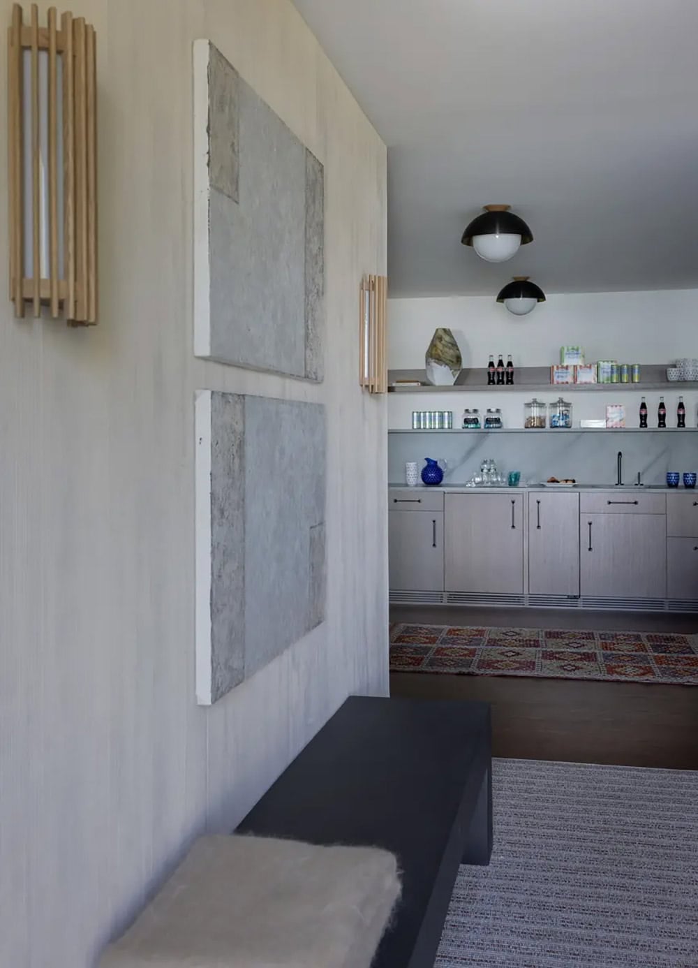 Hallway with abstract art leading to a wet bar with shelving