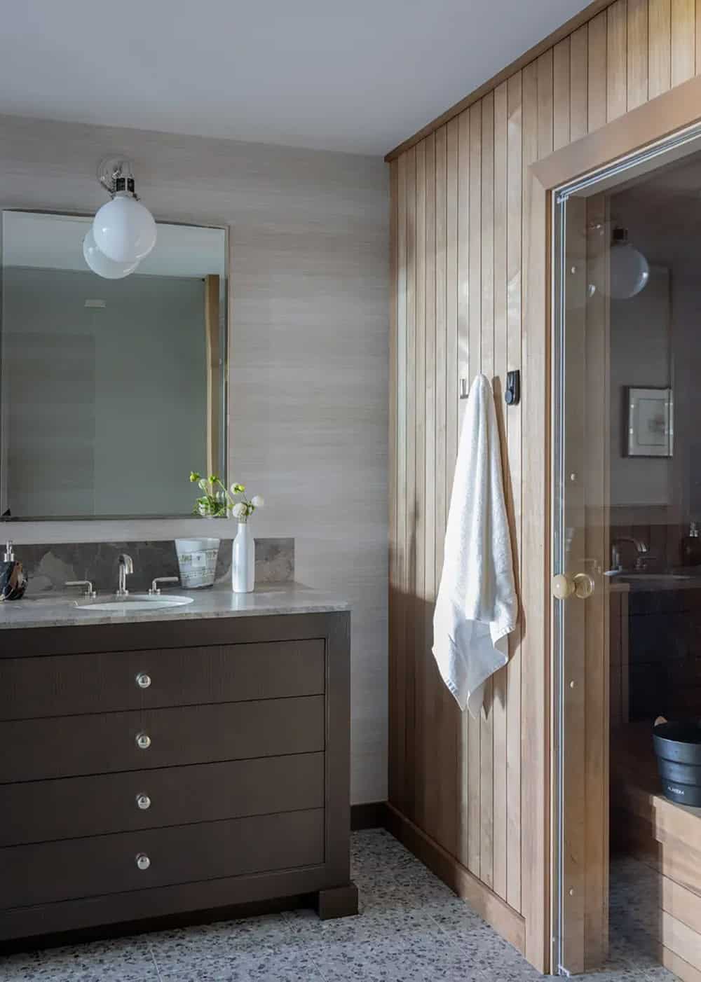 Sauna entry with wood paneling and marble vanity beside the door