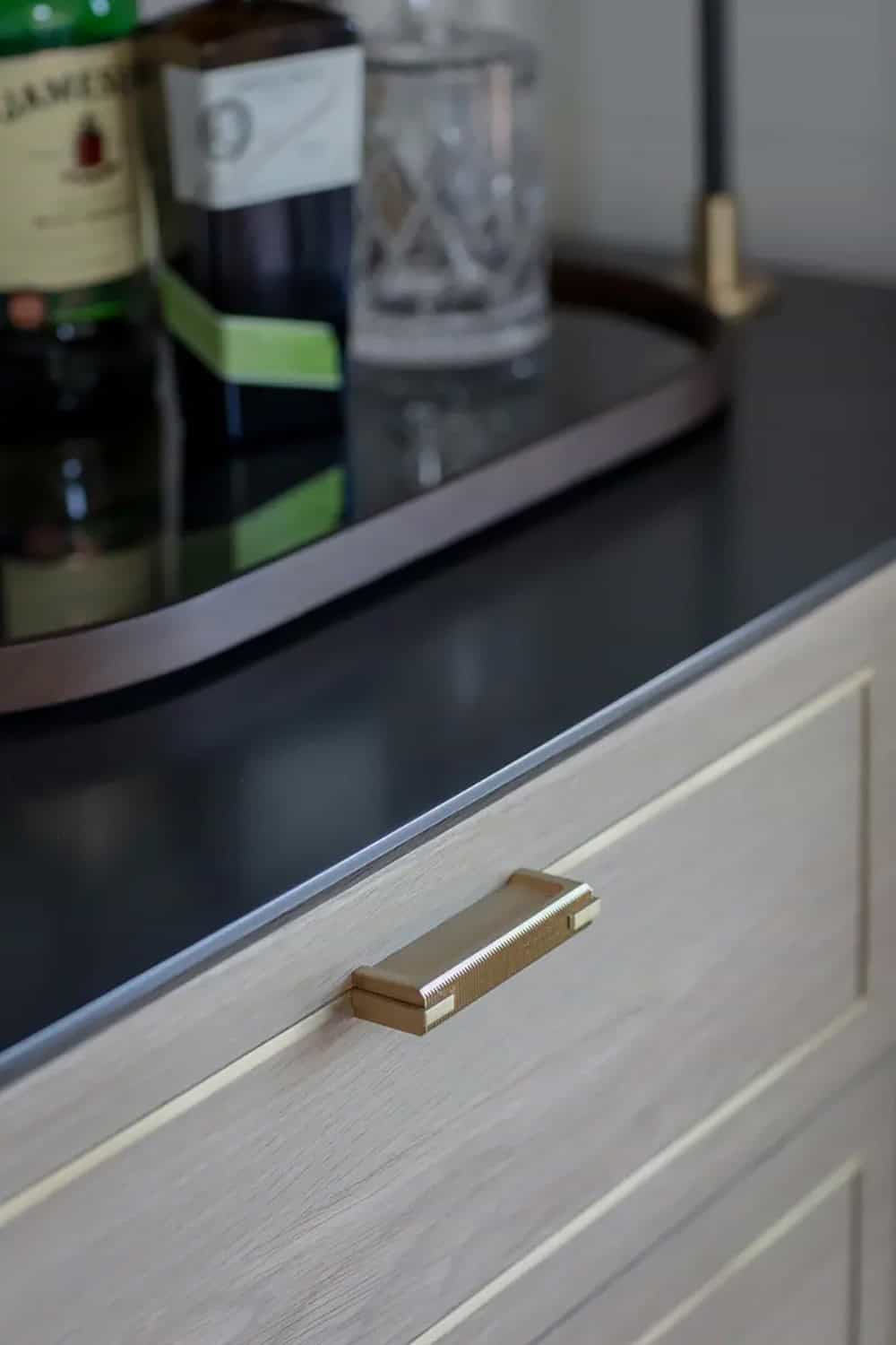 Close-up of a brass drawer pull on a wet bar cabinet