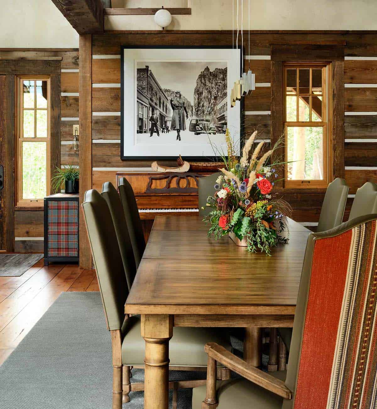 log cabin dining room with a dining table, chairs and a flower centerpiece