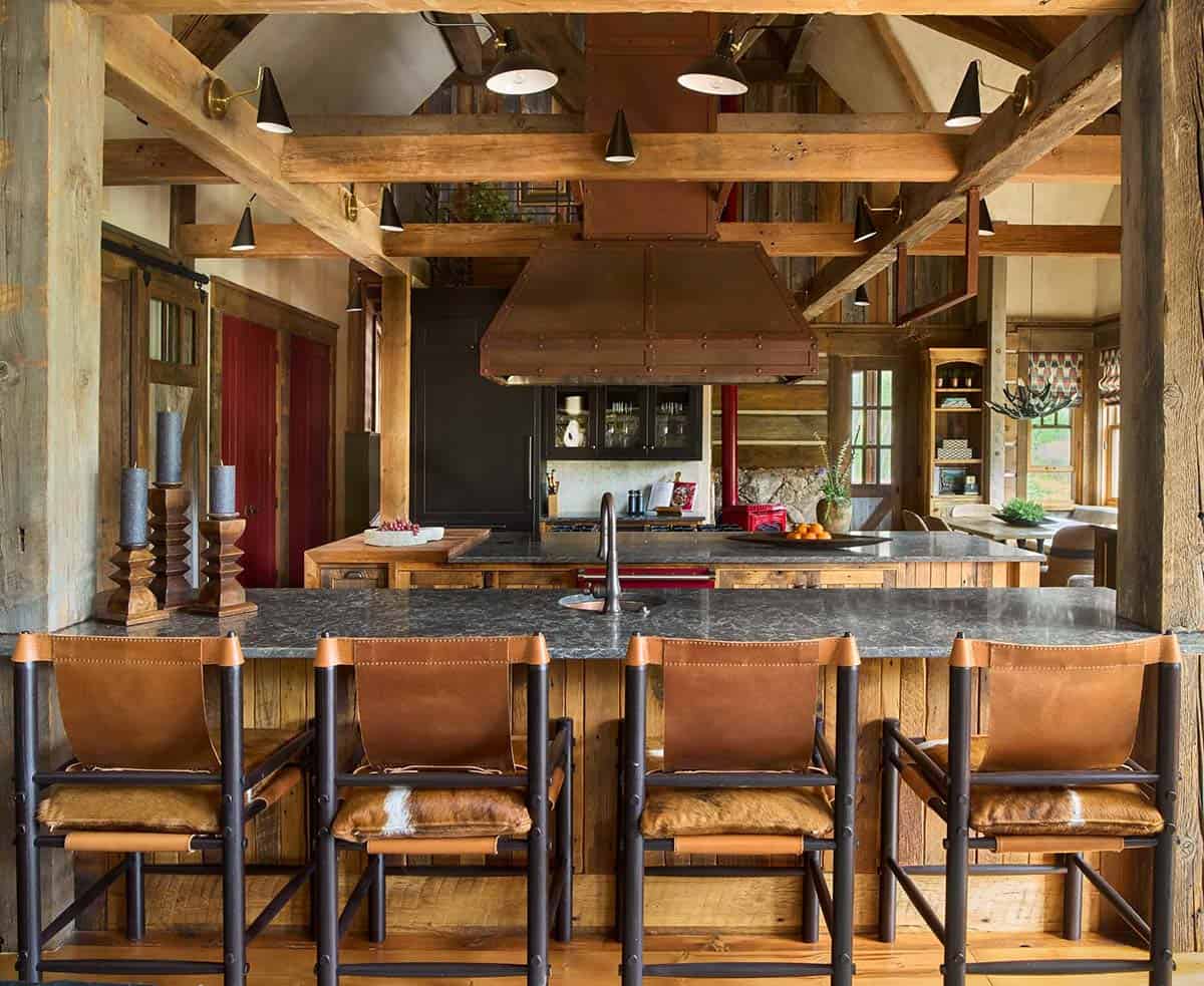 Kitchen island with leather bar stools under exposed timber beams