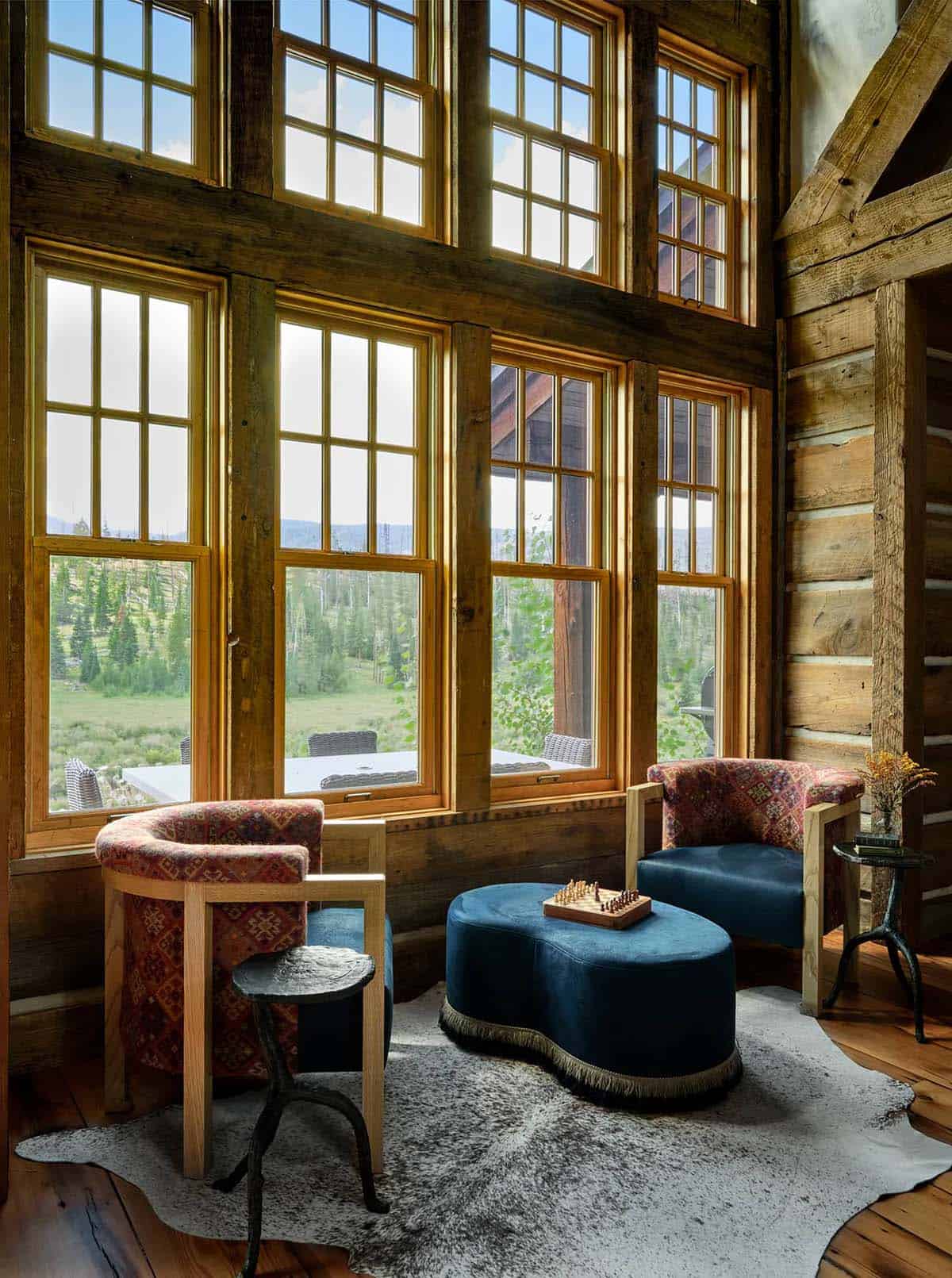 Conversation corner with Kilim chairs and ottomab beneath tall windows