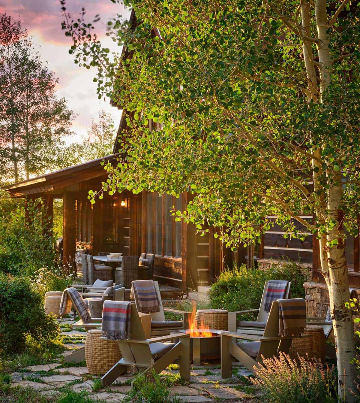 Backyard fire pit seating area beneath aspen trees at dusk