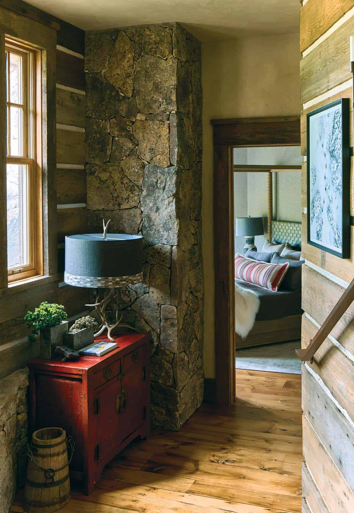 Stone pillar hallway with red cabinet leading to bedroom