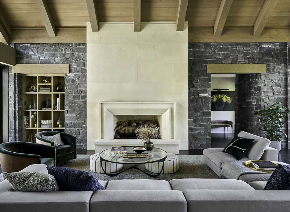 Wide view of living room with vaulted wood-beam ceiling and stone fireplace wall