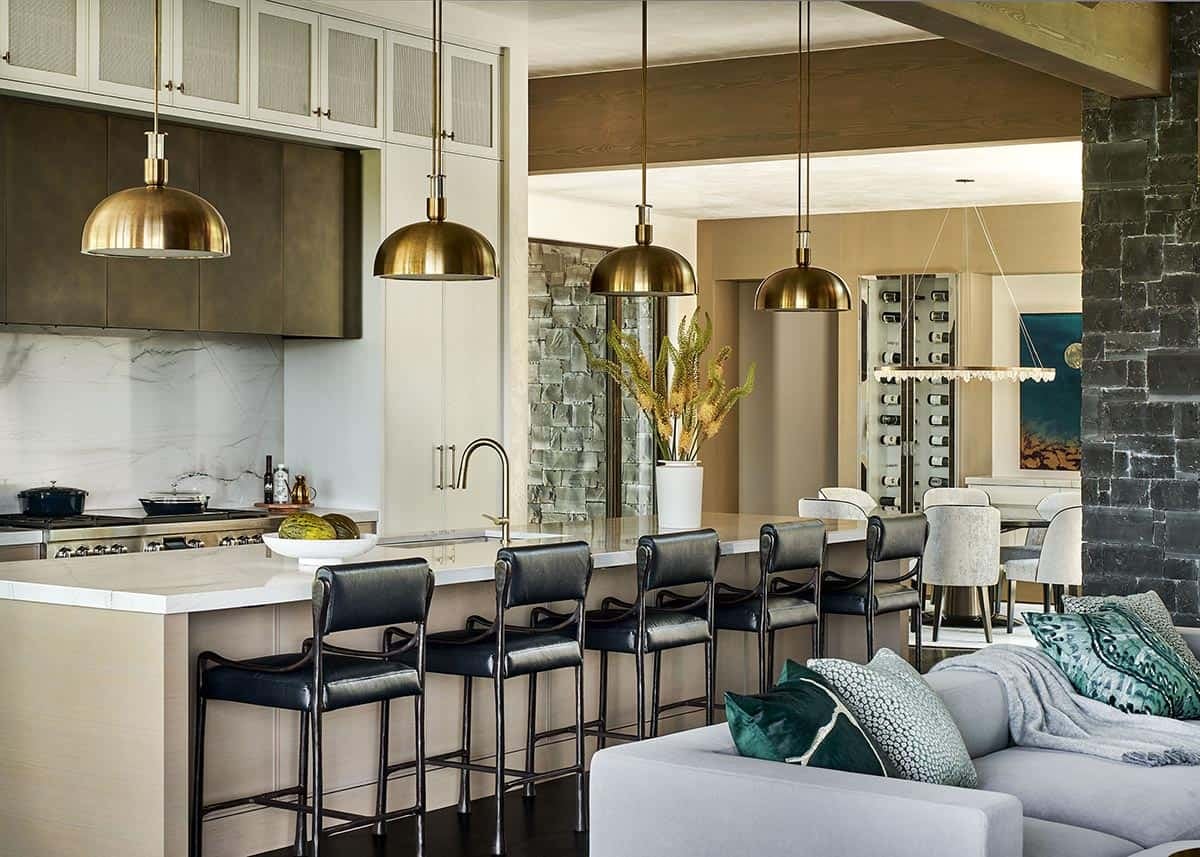 Contemporary kitchen with black bar stools and gold pendant lights.