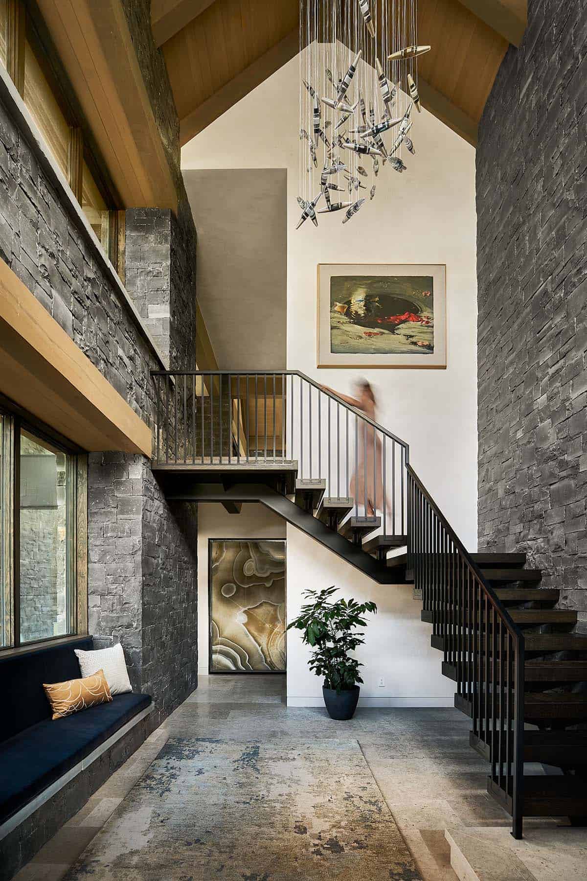 Staircase with sculptural hanging light and figure walking up the stairs