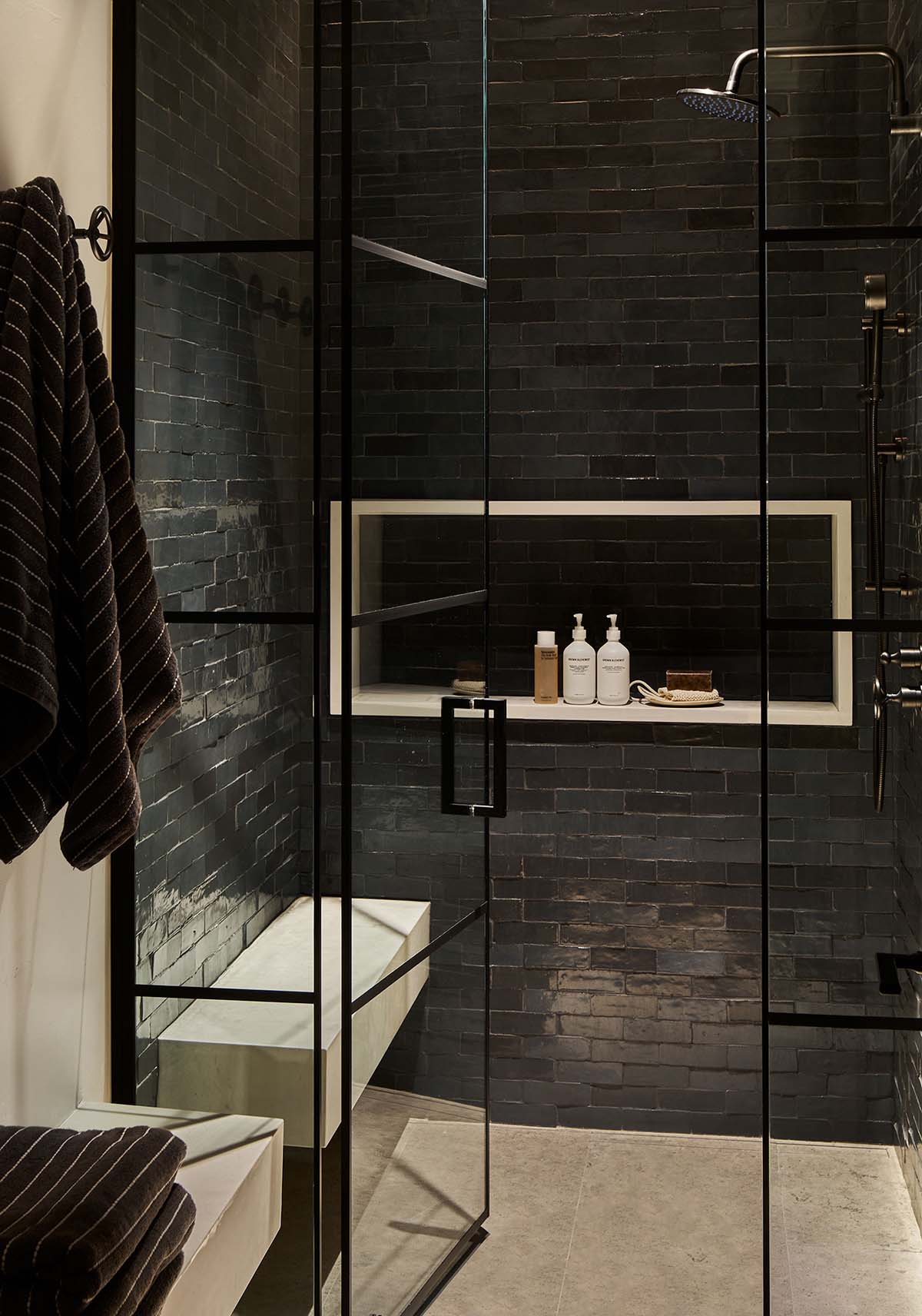 Walk-in shower with dark brick tile, built-in niche, and rainfall showerhead